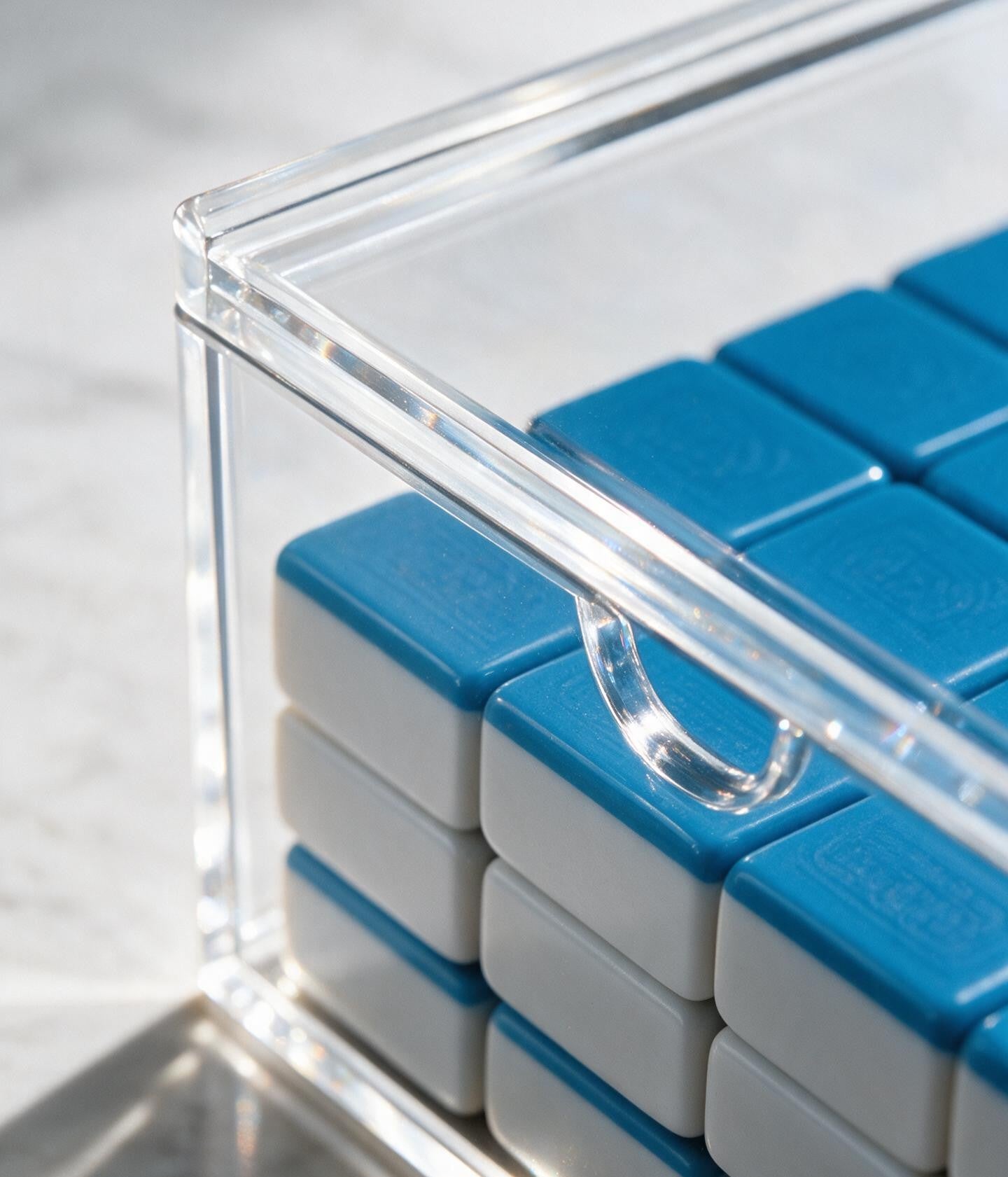 clear acrylic mahjong tile storage box with sliding lid for organizing, protecting, and displaying American mahjong tiles.