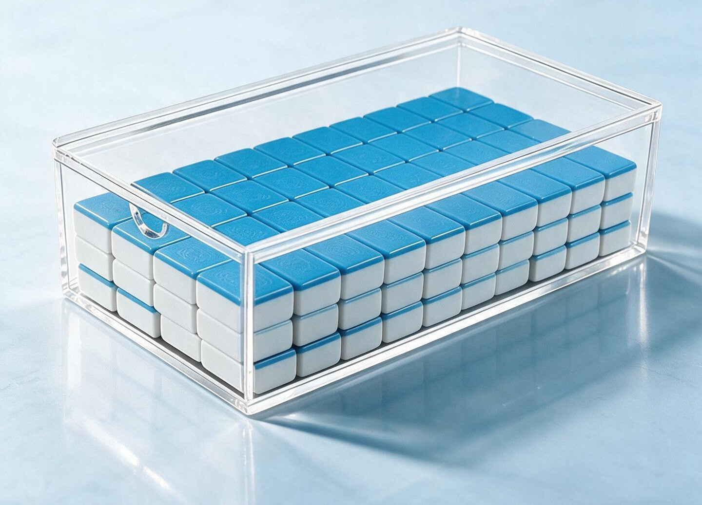 clear acrylic mahjong tile storage box with sliding lid for organizing, protecting, and displaying American mahjong tiles.